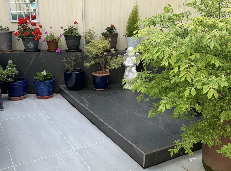 Silver patio with raised black tile area